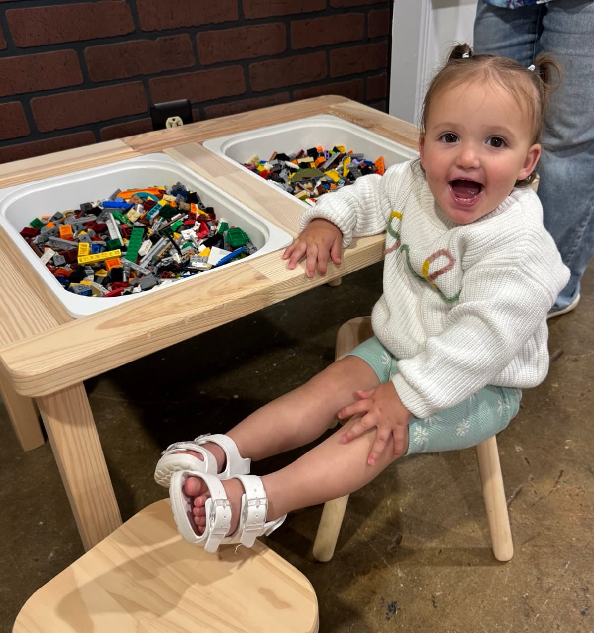 A happy little builder at the LEGO® play table